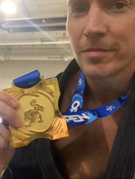 Brett Gillan holding up an IBJJF gold medal